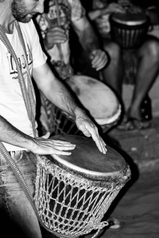 a black and white photo of a group of people playing drums, inspired by Samuel Silva, figuration libre, hand made, rasta, lots de details, summer night
