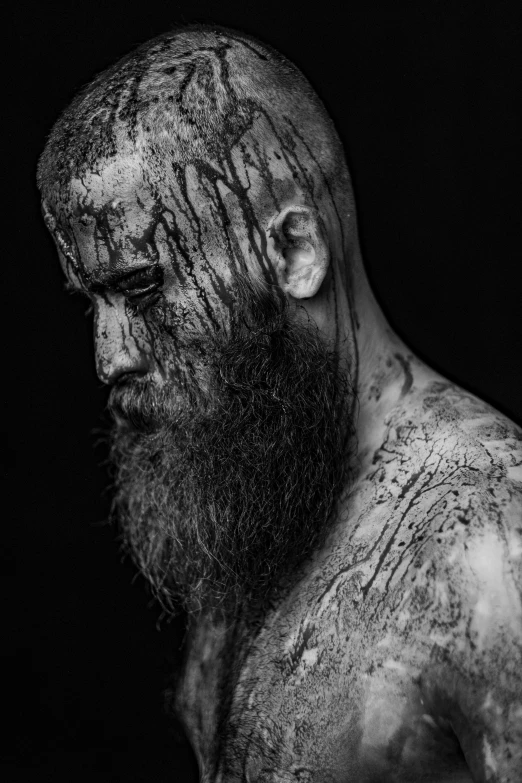 a black and white photo of a man with a beard, inspired by Oluf Høst, pexels contest winner, art photography, battle scars across body, painted portrait of rugged odin, shaved head, covered in blood