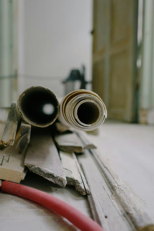 a couple of pipes sitting on top of a wooden floor, a picture, unsplash, arbeitsrat für kunst, damage paper, low quality photo, architectural photo, historical footage