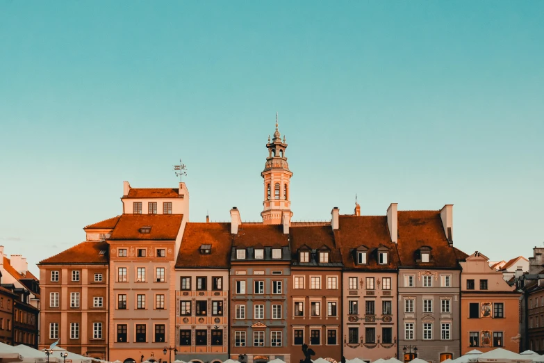 a large building with a clock tower on top of it, by Adam Marczyński, pexels contest winner, baroque, tenement buildings, in the style wes anderson, late afternoon light, square