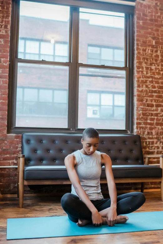 a woman sitting on a yoga mat in a living room, by Nina Hamnett, pexels contest winner, renaissance, depressed dramatic bicep pose, in an urban setting, profile image, promotional image