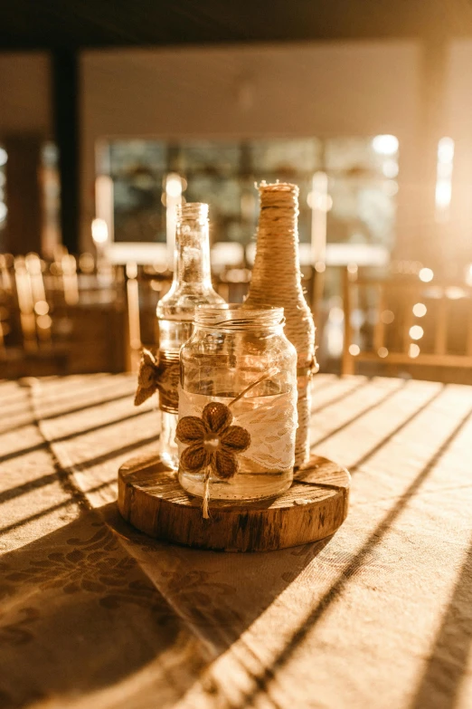 a couple of bottles sitting on top of a wooden table, on a candle holder, stunning sunny lighting, multiple details, indoor setting