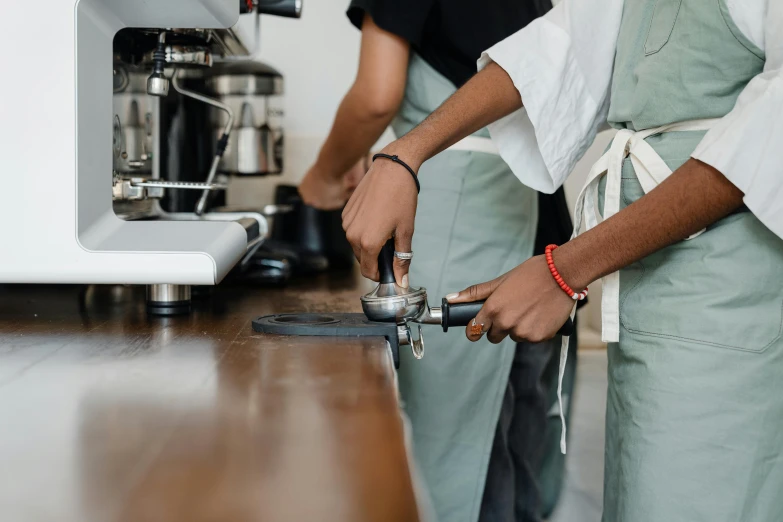 a couple of men standing next to each other in a kitchen, pexels contest winner, aussie baristas, pouring techniques, scrape off, stainless steal