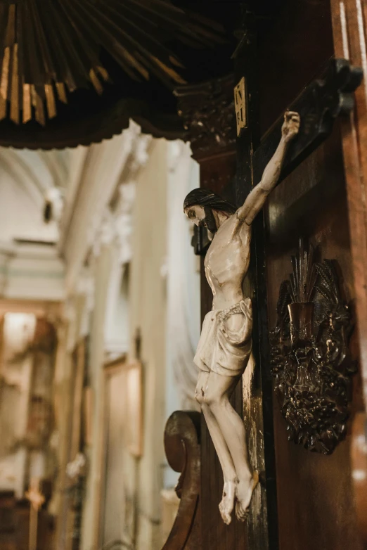 a statue of jesus on a cross in a church, by Johannes Martini, pexels contest winner, baroque, shelves full of medieval goods, seductive expression, in a museum room, hanging