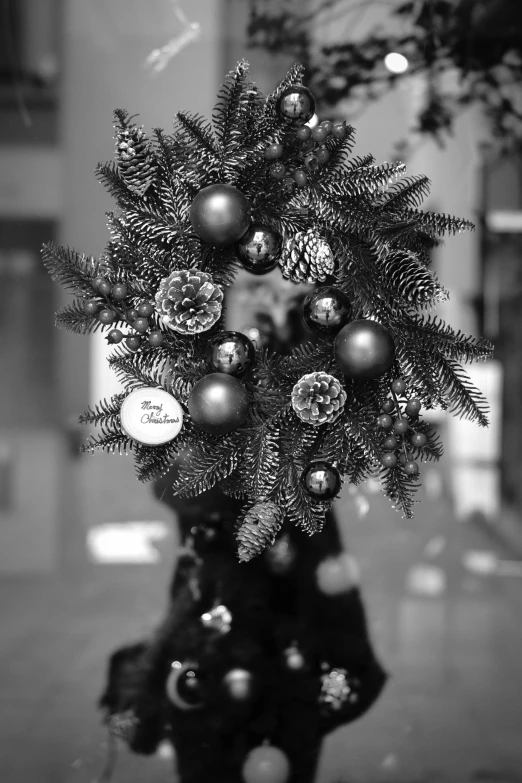 a black and white photo of a christmas wreath, inspired by Vivian Maier, realism, 中 元 节, candid photo, -n 8, the grinch