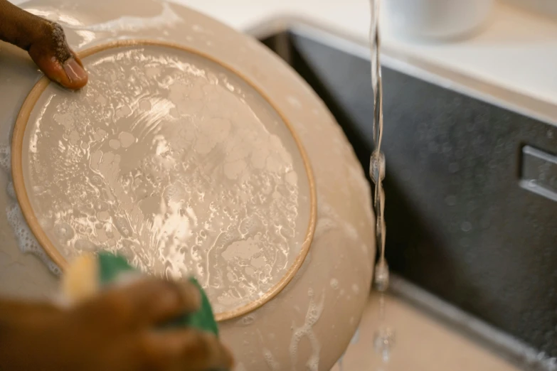 a close up of a person washing a plate, vessels, fan favorite, uncropped