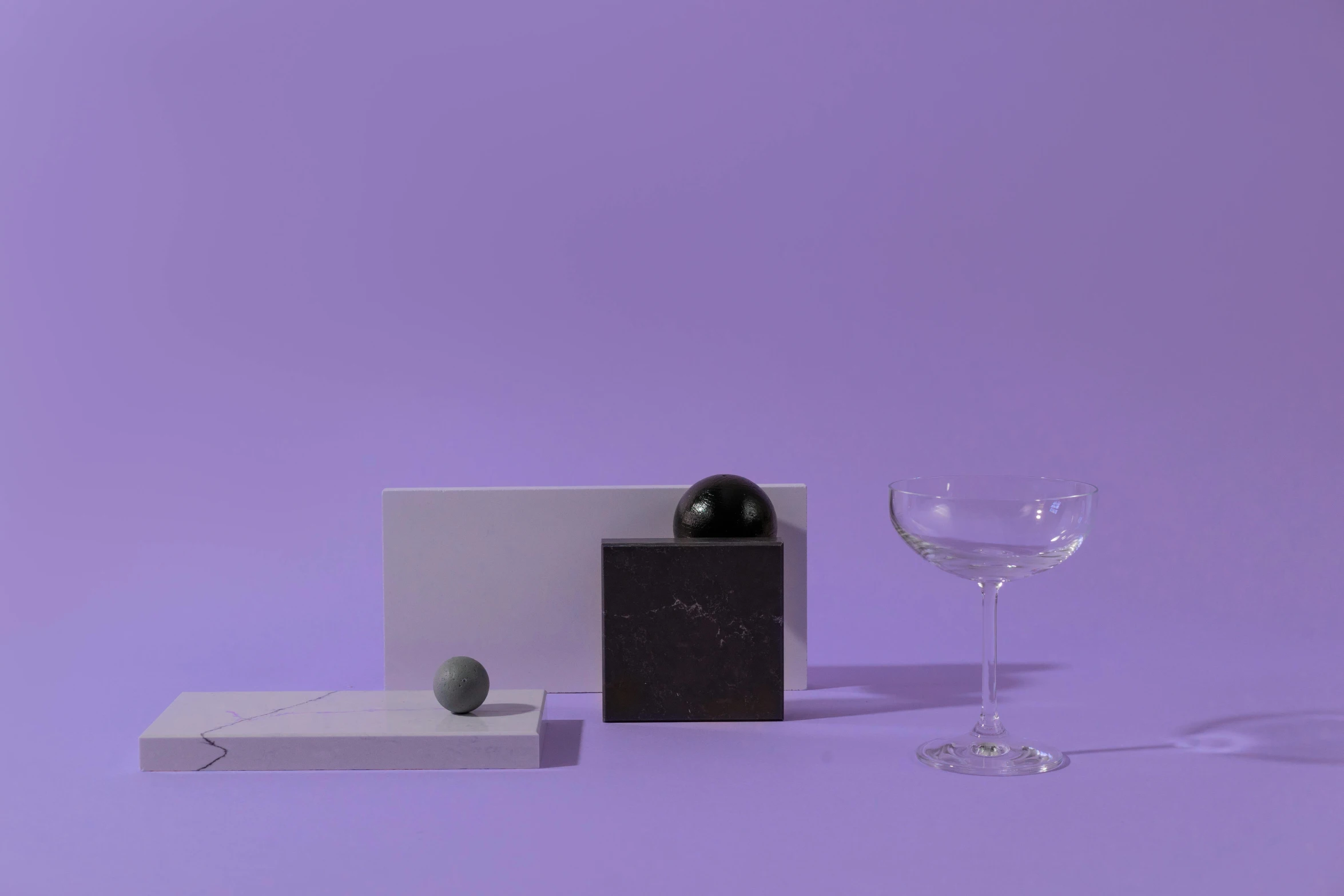 a glass of wine sitting on top of a table, inspired by Yanjun Cheng, postminimalism, flying black marble balls, violet theme, minimal artifacts, detailed product image