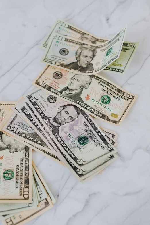 a pile of money sitting on top of a table, on a white table