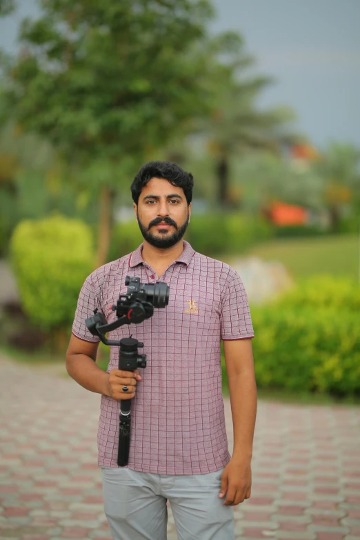 a man standing in front of a camera on a tripod, by Riza Abbasi, avatar image, profile picture, khyzyl saleem, islamic