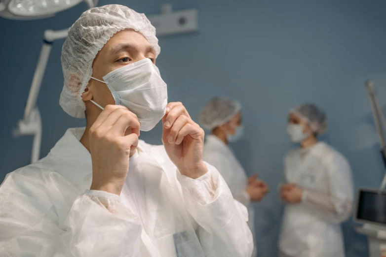 a woman in a surgical gown brushing her teeth, happening, masked doctors, bao pham, profile image, surgical gown and scrubs on