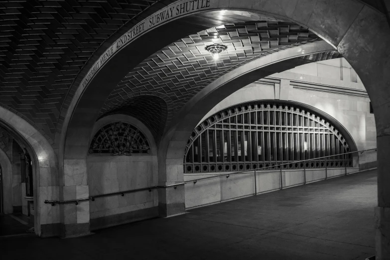 a black and white photo of a train station, by Dennis Flanders, unsplash contest winner, art nouveau, entrance to a dark tunnel, interior of staten island ferry, it's late at night, golden curve structure