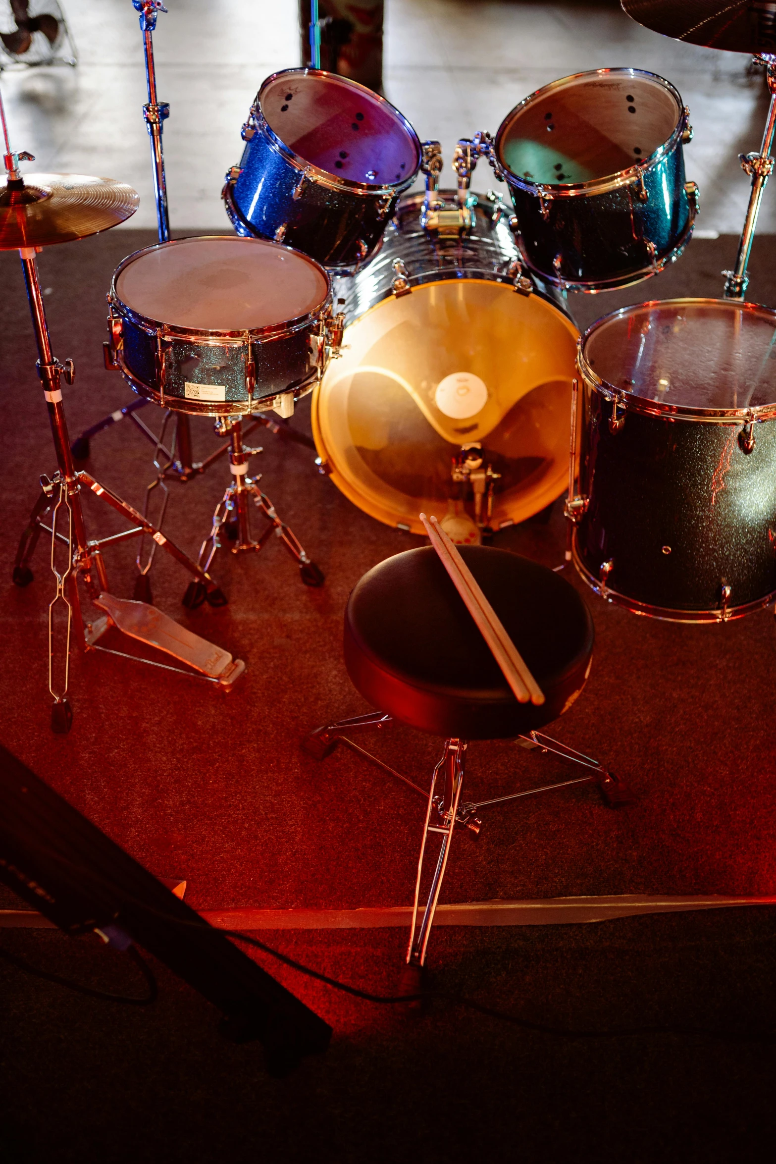 a close up of a drum set on a stage, by Dave Melvin, photorealism, wide high angle view, nightclub, panoramic, back room