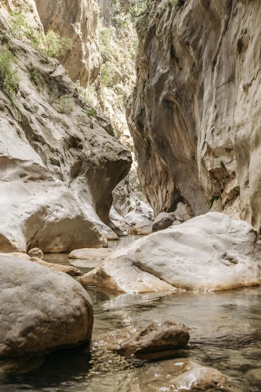 a man standing on top of a rock next to a river, les nabis, inside a gorge, malibu canyon, dry archways, subtle