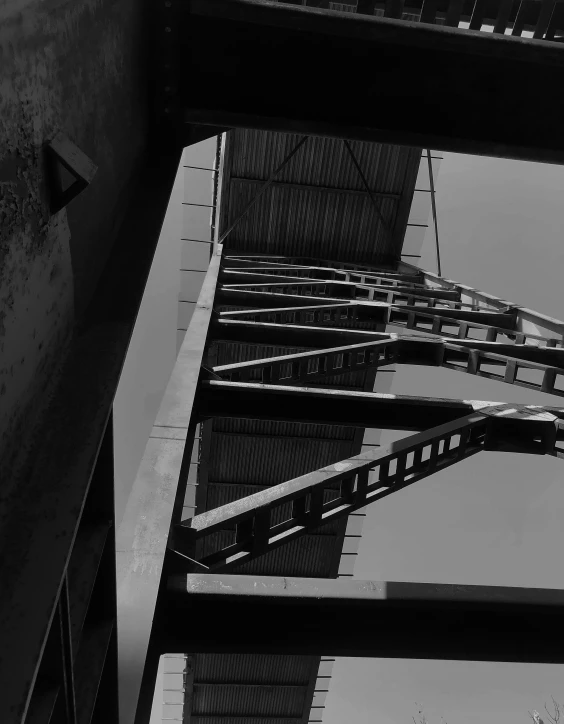 a black and white photo of a bridge, a black and white photo, inspired by Alexander Rodchenko, brutalism, standing on a ladder, industrial colours, low angle!!!!, shot from cinematic