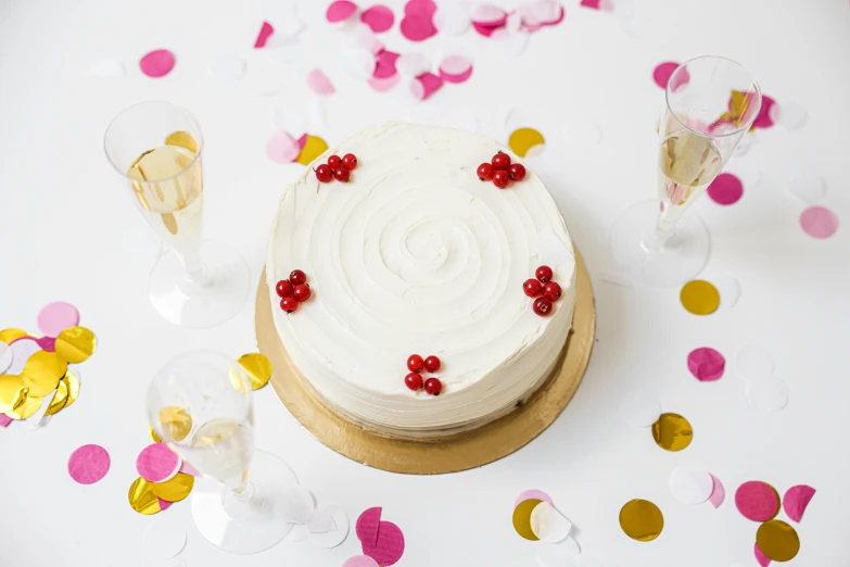 a cake sitting on top of a table covered in confetti, product shot, white red, pur champagne damery, thumbnail