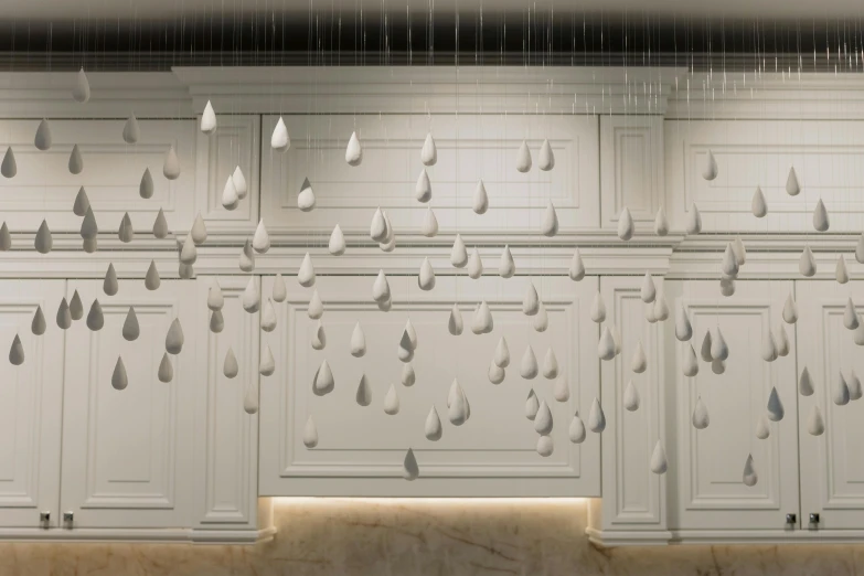 a kitchen with white cabinets and raindrops hanging from the ceiling, a marble sculpture, inspired by Leandro Erlich, unsplash, conceptual art, low - relief stone sculpture, tear drop, houdini rendering, jeongseok lee