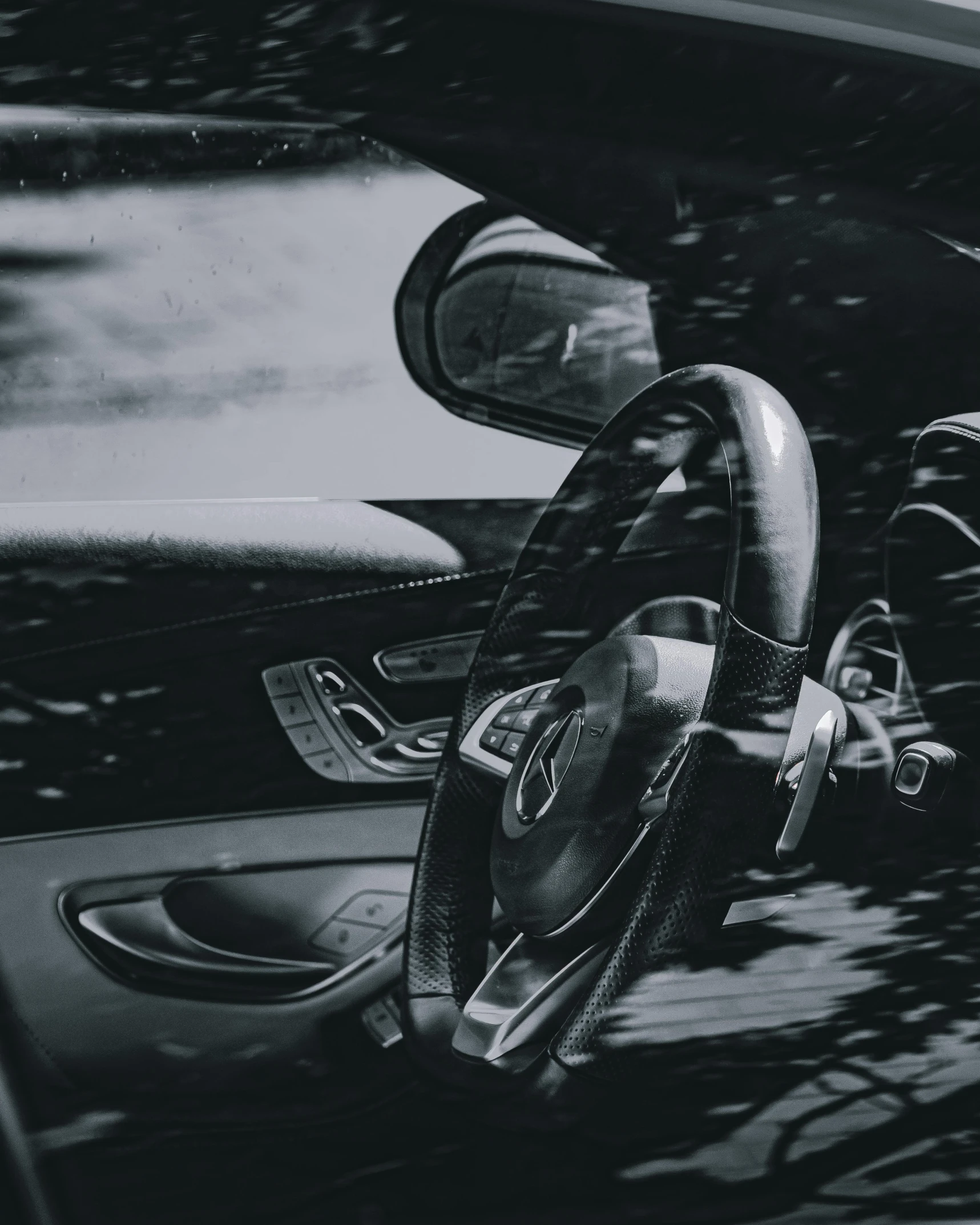 a black and white photo of a car with a steering wheel, pexels contest winner, grey and dark theme, instagram story, album cover, grainy black and white footage