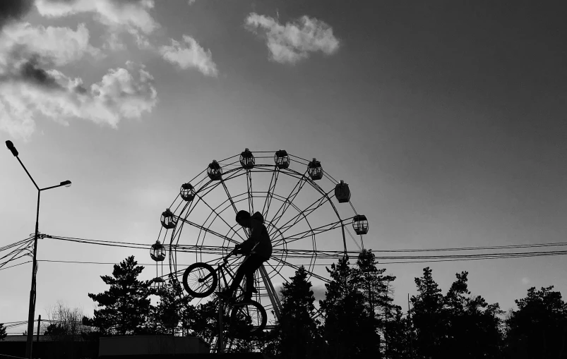 a black and white photo of a ferris wheel, a black and white photo, by Mathias Kollros, kinetic art, biker, sunset!!!, hitoshi ashinano, summer afternoon