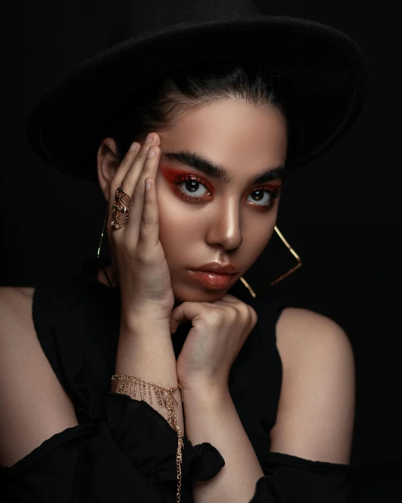 a close up of a person wearing a hat, an album cover, inspired by Hedi Xandt, trending on pexels, big bold thick eyebrows, hand on her chin, dark palette, model posing