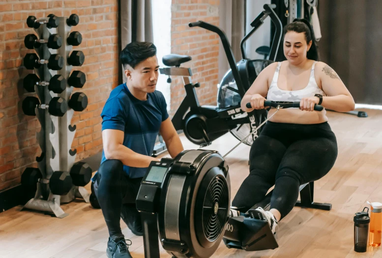 a man and a woman working out on a rowing machine, by Emma Andijewska, hurufiyya, low quality photo, damien tran, 8k octan advertising photo, background image