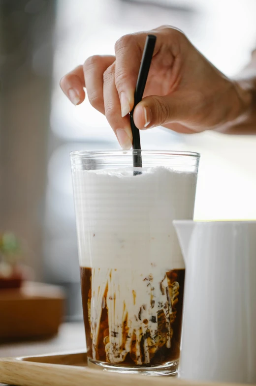 a close up of a person holding a spoon in a cup, iced latte, mixing drinks, kano tan'yu, 4l