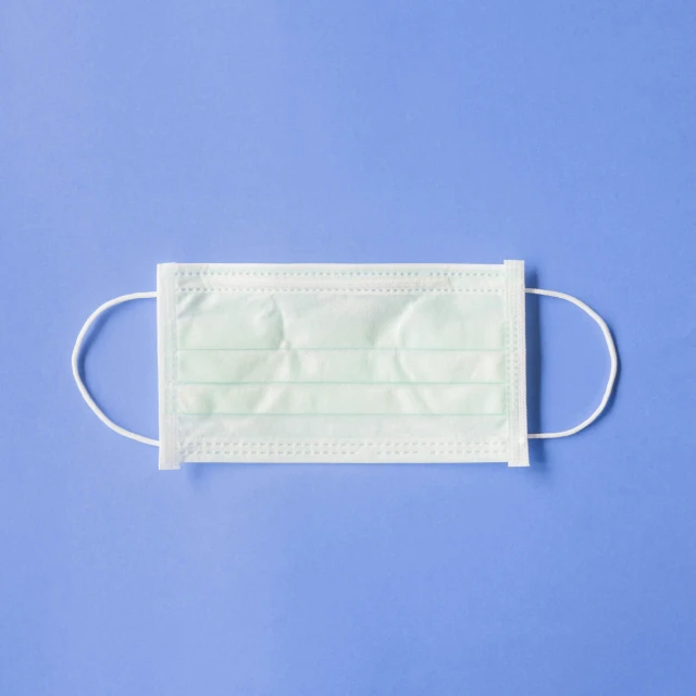 a surgical mask on a blue background, square face, product image, white-space-surrounding, white background and fill