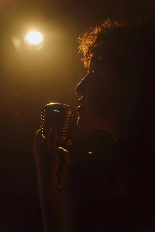 a woman singing into a microphone in the dark, an album cover, pexels, happening, cinematic backlit lighting, curly haired, ( ( theatrical ) ), movie scene