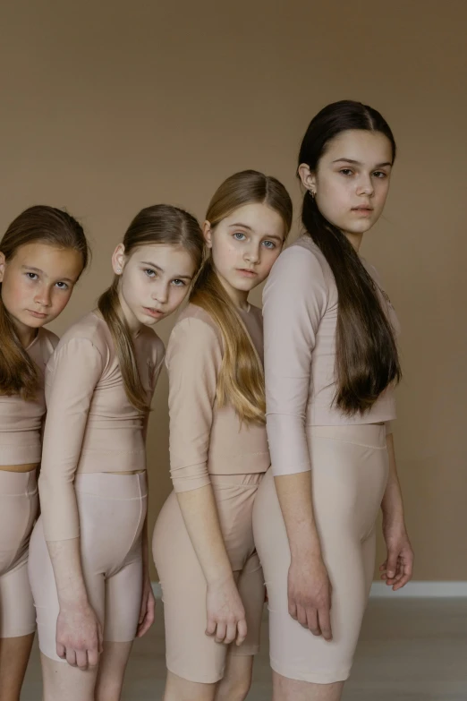 a group of young women standing next to each other, inspired by Vanessa Beecroft, trending on pexels, renaissance, children, beige colors, pink, leotard