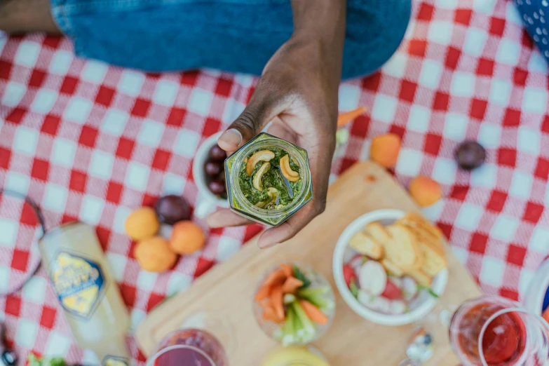 a close up of a person holding a glass of wine, by Carey Morris, pexels contest winner, having a picnic, moringa juice, relish, humus