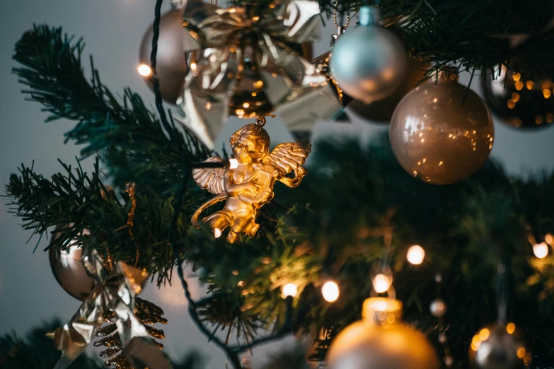 a close up of a christmas tree with ornaments, pexels, baroque, an angel, thumbnail, épaule devant pose, well lit