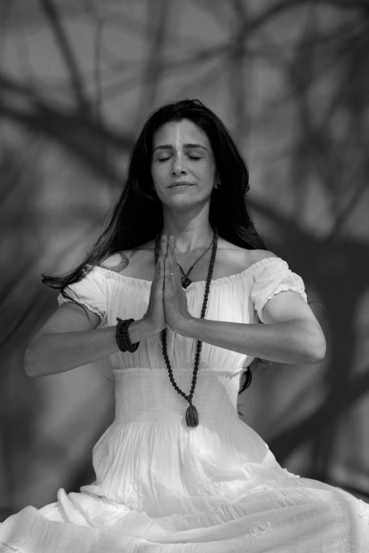 a black and white photo of a woman doing yoga, inspired by Marina Abramović, renaissance, the oracle of trees, hands crossed, jennifer connelly, wearing white cloths