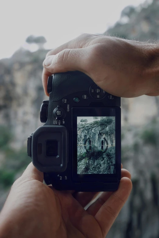 a close up of a person holding a camera, a picture, looking into a mysterious cave, zoomed in shots, framed in image, video footage