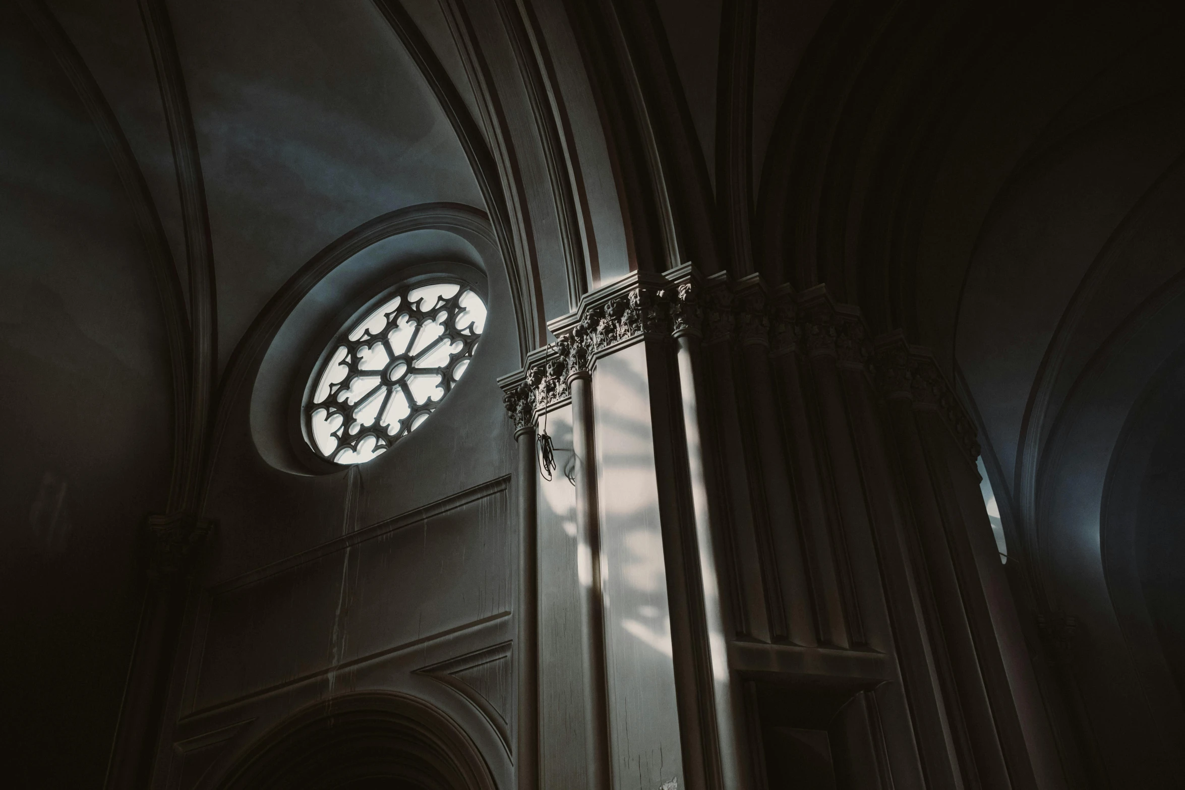 the sun shines through a stained glass window in a cathedral, a black and white photo, unsplash contest winner, light and space, neoclassicism style, round windows, moody hazy lighting, high - angle view