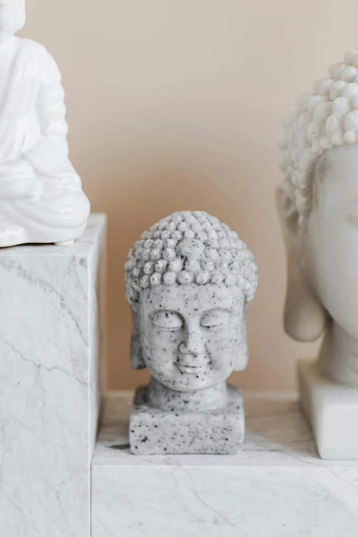 a couple of statues sitting next to each other, a marble sculpture, trending on pexels, knick knacks, the buddha, close up head shot, full product shot