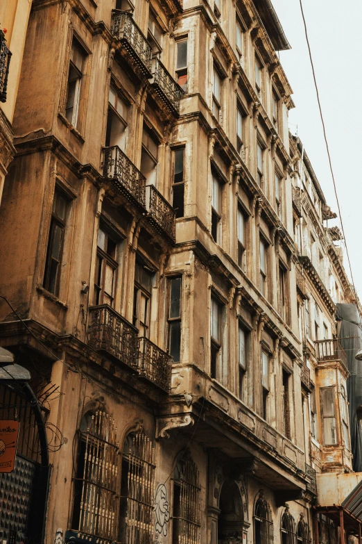 a group of people walking down a street next to tall buildings, inspired by Elsa Bleda, pexels contest winner, art nouveau, istanbul, old house, yellowed with age, exterior view