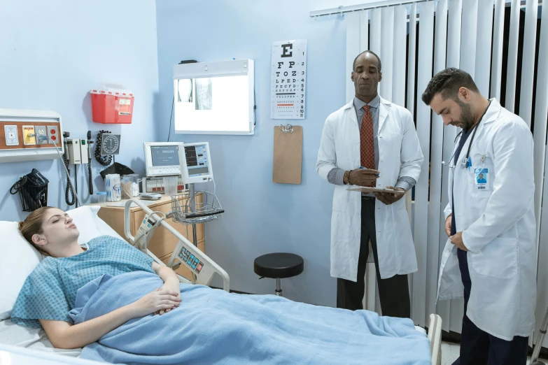 a group of doctors standing around a woman in a hospital bed, lance reddick, cinestill colour, lachlan bailey, realistic »