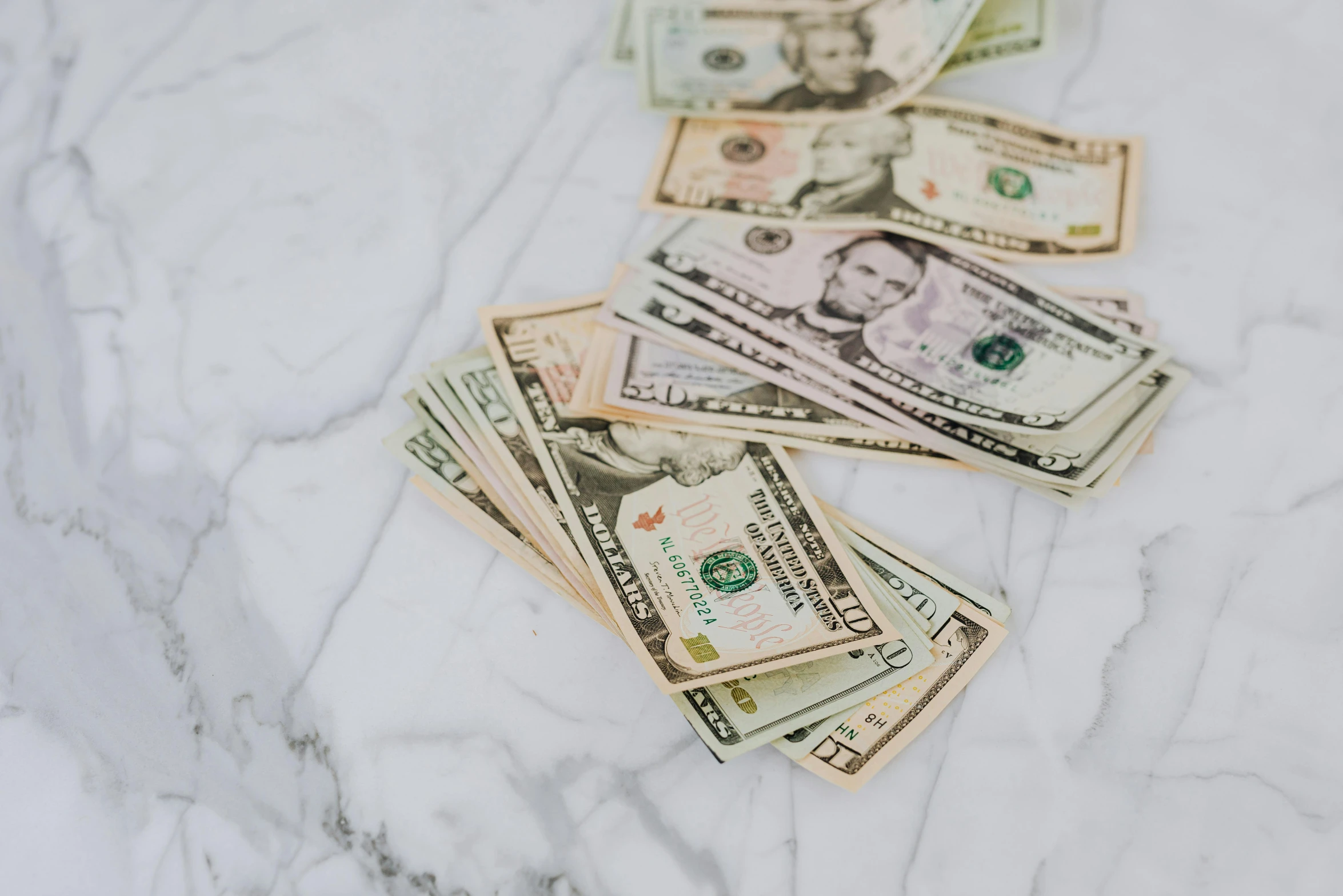 a pile of money sitting on top of a marble counter, trending on unsplash, background image, fan favorite, 2000s photo, ad image