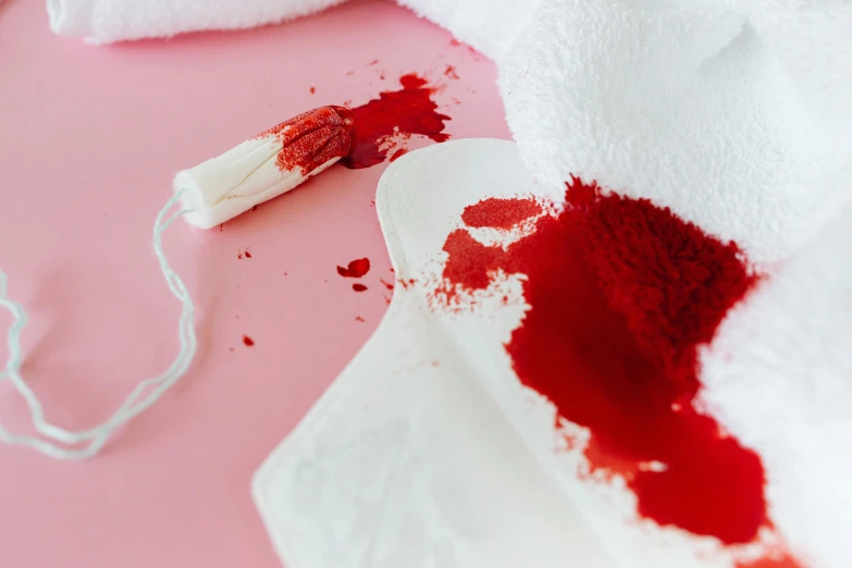 a white towel sitting on top of a pink table, a cross stitch, trending on pexels, process art, blood dripping from mouth, red paint, bloody knife, split hair dye