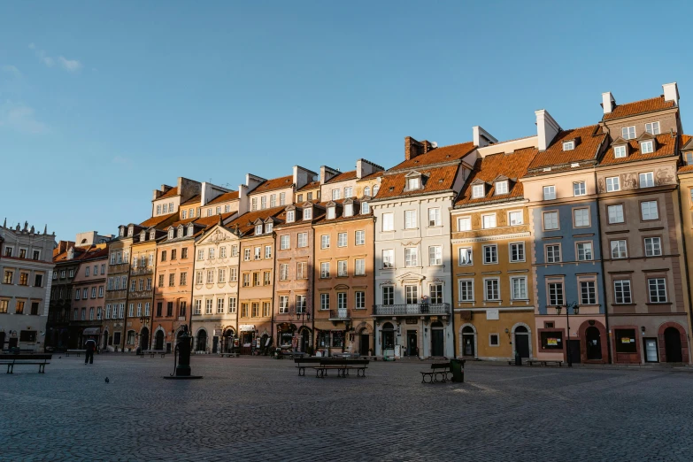 a group of buildings sitting on top of a cobblestone street, warsaw, golden hues, square, high-quality photo