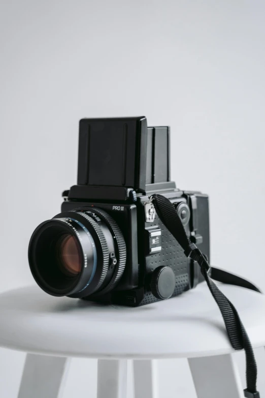 a camera sitting on top of a white stool, by Sven Erixson, unsplash, hasselblad medium format, 1980s photograph, towering over the camera, highly realistic photograph