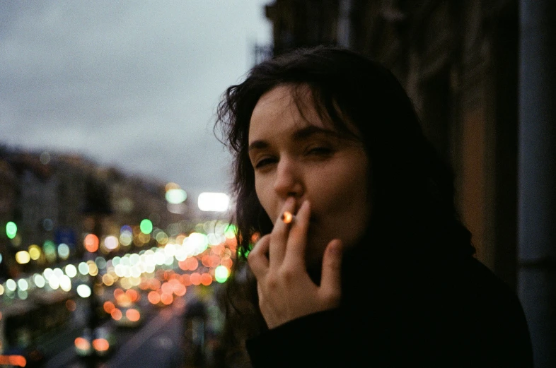 a woman standing on a balcony smoking a cigarette, inspired by Elsa Bleda, pexels contest winner, police lights shine on her face, billie eilish, outside alone smoking weed, french girl