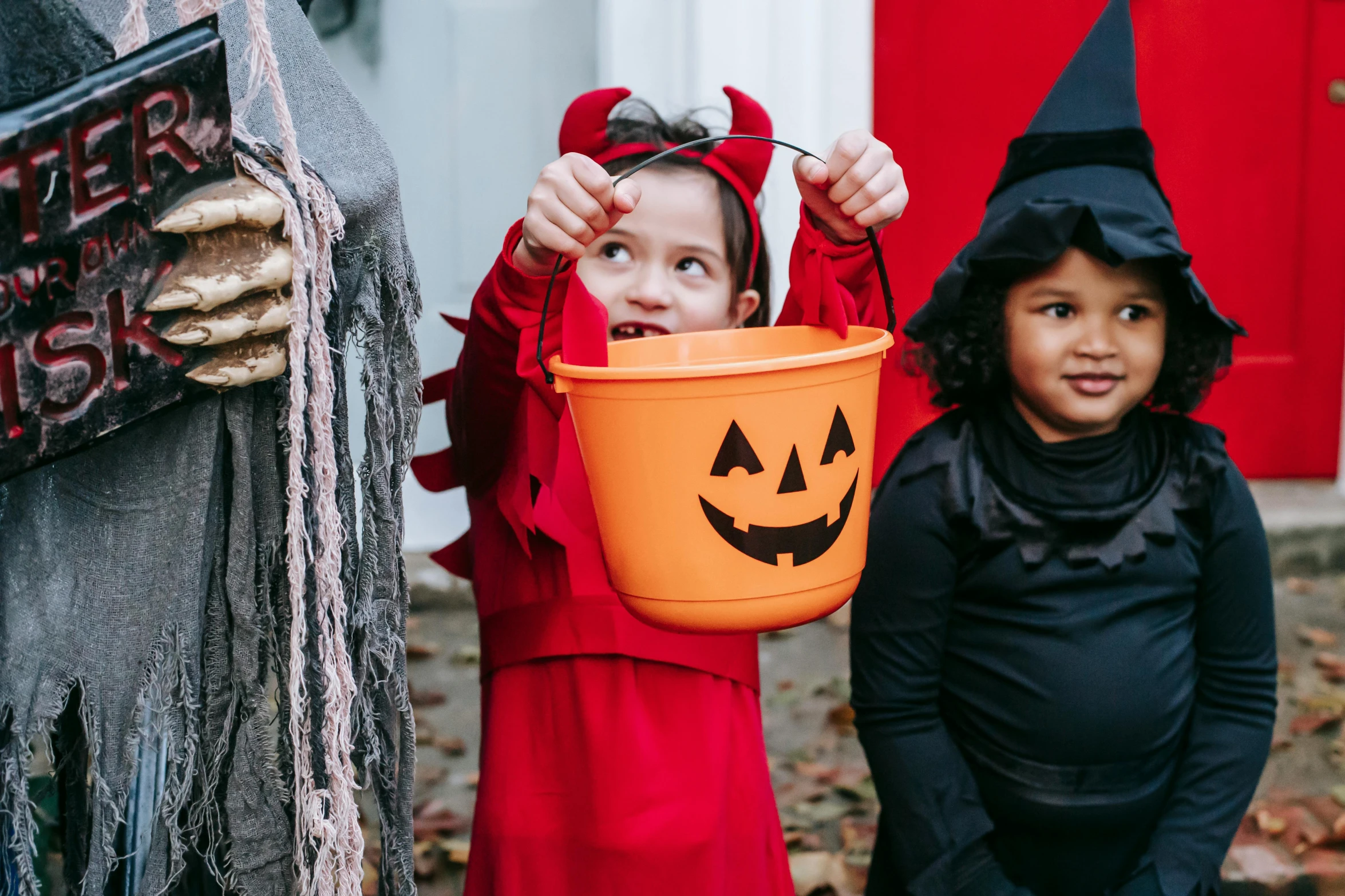 a couple of kids standing next to each other, pexels, trick or treat, instagram post, grey, wearing red attire