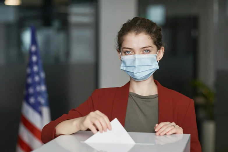 a woman putting a voting paper into a voting box, surgical mask covering mouth, avatar image, thumbnail, professional photo