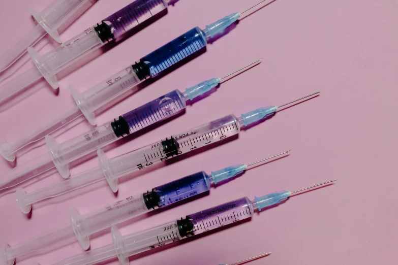 a bunch of sylls sitting on top of a pink surface, trending on pexels, plasticien, syringes, purple blue color scheme, syringe, swarovski crystals