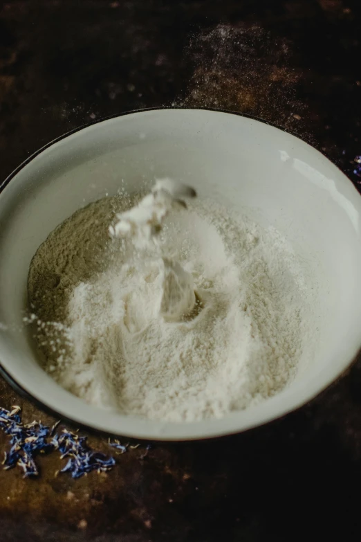 a white bowl sitting on top of a wooden table, flour dust, detailed product image, silver，ivory, ignant