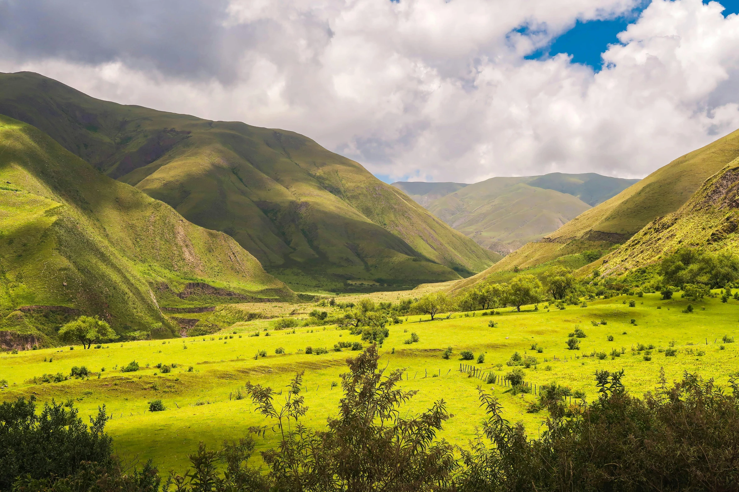 a lush green valley with mountains in the background, hurufiyya, fan favorite, quechua, conde nast traveler photo