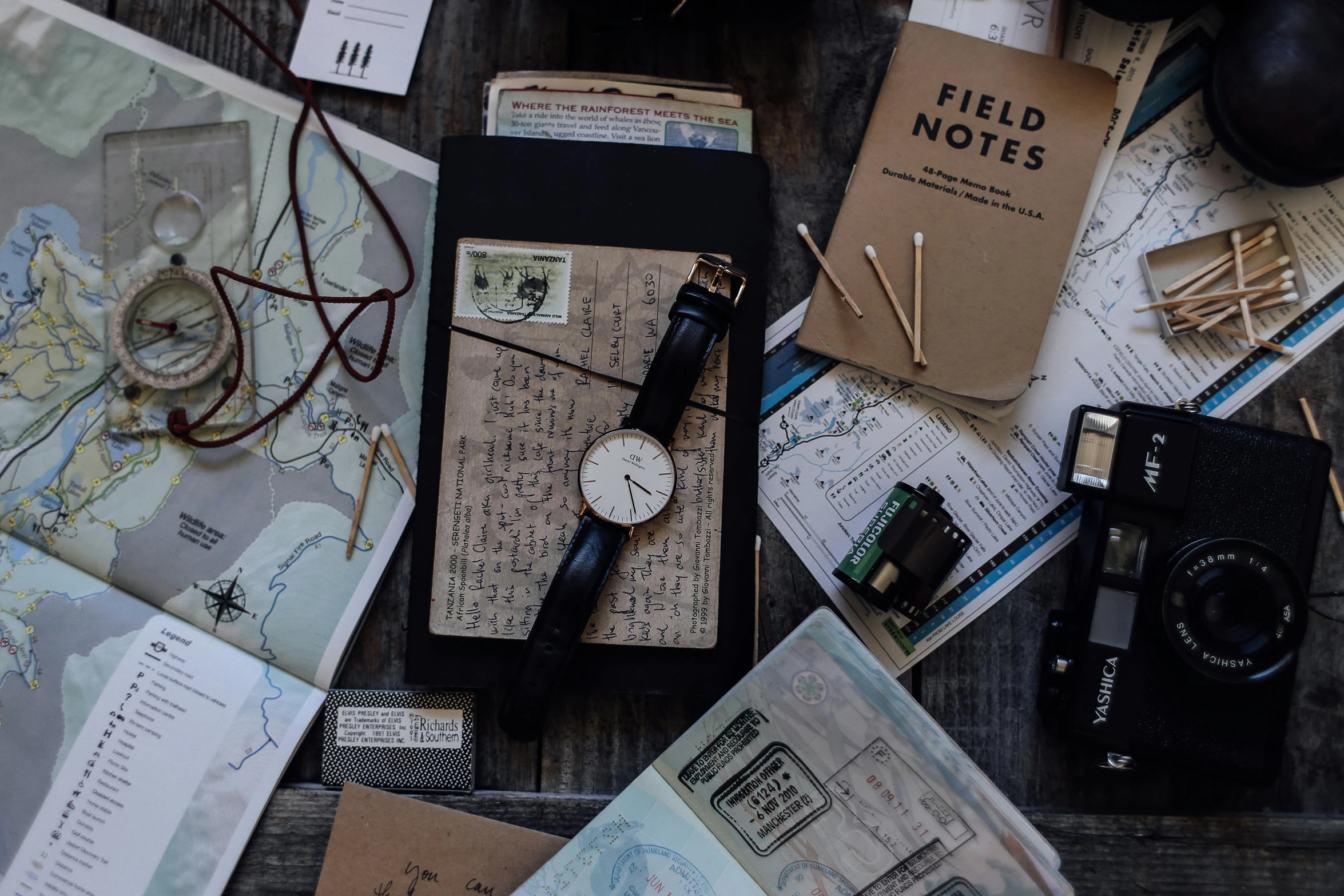 a bunch of papers sitting on top of a wooden table, by Emma Andijewska, pexels contest winner, time travel theme, moody : : wes anderson, passport, hunting
