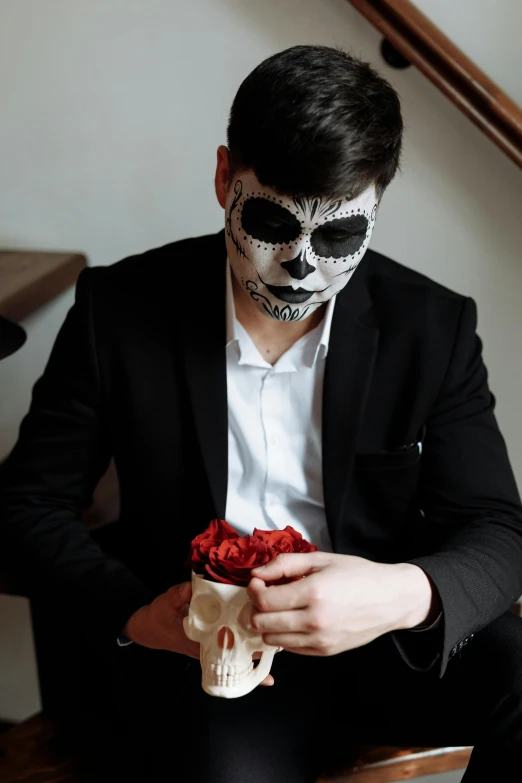 a man in day of the dead makeup holding a rose, inspired by Hedi Xandt, pexels contest winner, wearing tuxedo, teenage boy, skulls, gif