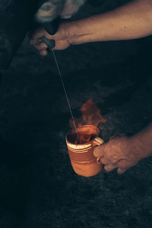 a close up of a person pouring something into a cup, bonfire, high quality product image”, “ iron bark, terracotta