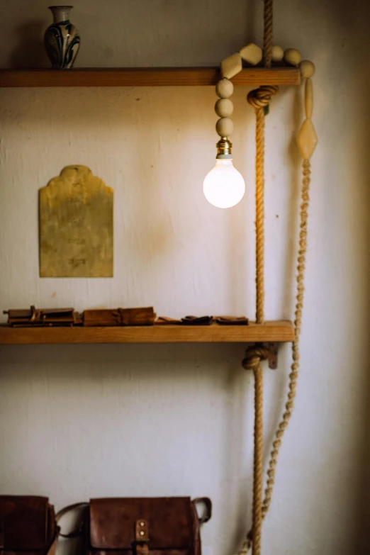 a brown purse sitting on top of a wooden shelf, by Elsa Bleda, renaissance, cafe lighting, rope, ignant, small room